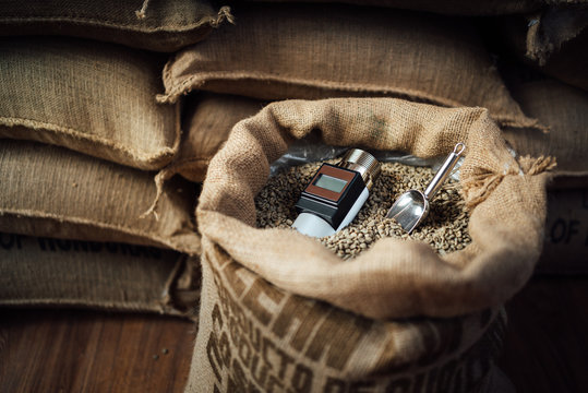 working device for measuring the humidity of coffee beans in a bag with a metal scoop, in the background
