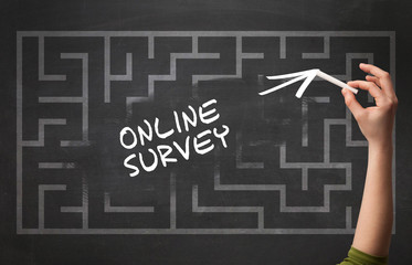 Hand drawing ONLINE SURVEY inscription with white chalk on blackboard, new business concept