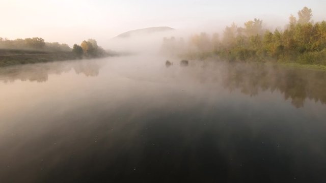 The remain of the reef of the ancient sea, composed of limestone - shikhan Kushtau. Fog on the Belaya river. Aerial view.