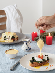 Eggs Benedict with Dutch egg and butter sauce and red caviar. Close-up. Tasty breakfast with poached eggs. Vertical orientation.