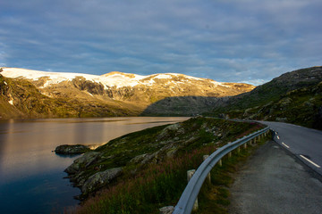 Road near a lake and mountains in the morning in Norway