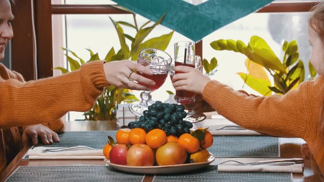 A family sitting in the restaurant clinking glasses of juice