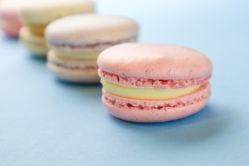 Tasty sweet macaron cakes on color background