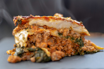 piece of meat lasagna and baked spinach