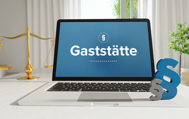 Gaststätte – Recht, Gesetz, Internet. Laptop im Büro mit Begriff auf dem Monitor. Paragraf und Waage. .