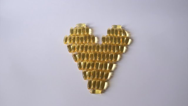 Heart made of pills Omega-3 gold Fish Oil. Cod liver oil medicines. Vitamins supplements pills Stop motion medical concept 