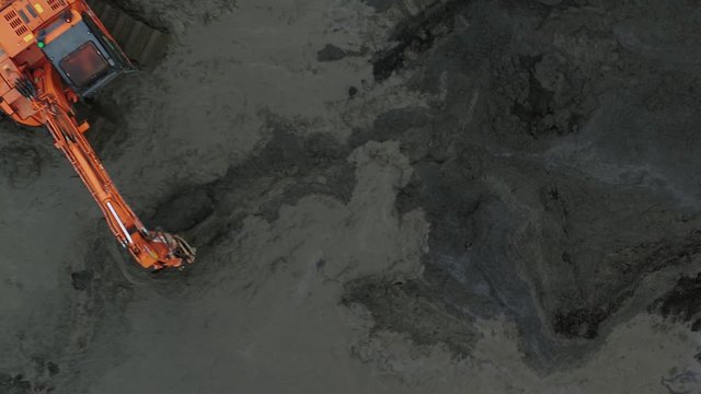 Top down aerial view of a digger mud on a construction site.