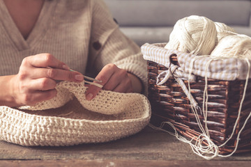 Knitting.Crocheting a hobby and lifestyle, Woman's hands knit from light yarn at home, mood,...