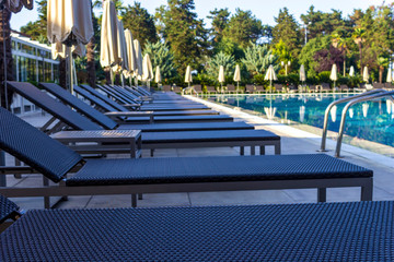 Sun beds by the pool in the open air. Pool at the spa resort.
