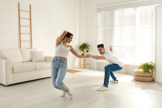 Beautiful young couple dancing in living room