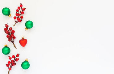 Festive background, branch of hawthorn and Christmas tree balls on a white background, flat lay, top view, copy space