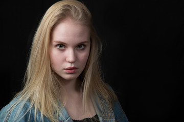 Portrait of a beautiful girl, blonde on a black background.