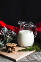 Fresh milk and Christmas cookies with Christmas decorations on a wooden table