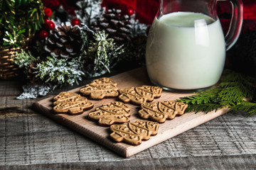 Fresh milk and Christmas cookies with Christmas decorations on a wooden table