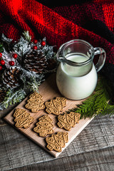 Fresh milk and Christmas cookies with Christmas decorations on a wooden table
