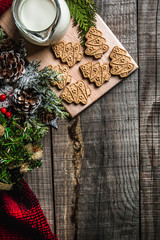 Fresh milk and Christmas cookies with Christmas decorations on a wooden table