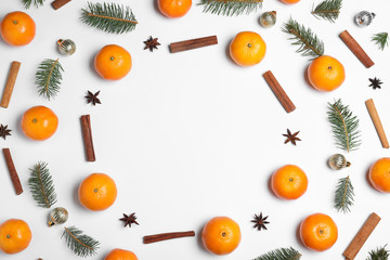 Flat lay composition with ripe tangerines, fir branches, cinnamon and Christmas decor on white background. Space for text