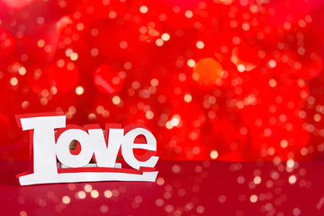 Word love on a red background with bokeh, holiday card banner, wedding invitation