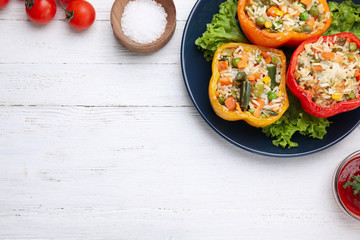 Tasty stuffed bell peppers served on white wooden table, flat lay. Space for text