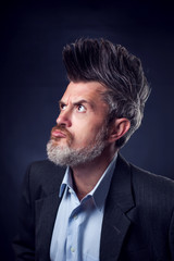 Fototapeta premium A portrait of bearded man with iroquois wearing suit