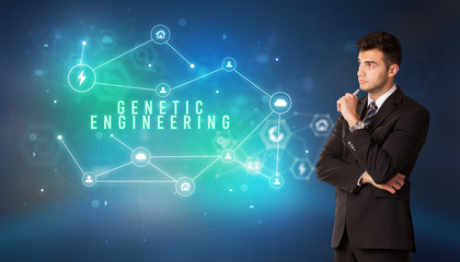 Businessman in front of cloud service icons with GENETIC ENGINEERING inscription, modern technology concept