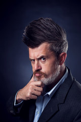 A portrait of bearded man with iroquois wearing suit