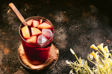 pitcher of cold sangria with fruit on a dark background