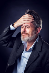 Obraz premium A portrait of bearded man with iroquois wearing suit showing has problems. People and emotions concept