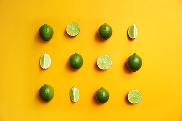 Flat lay composition with fresh juicy limes on yellow background
