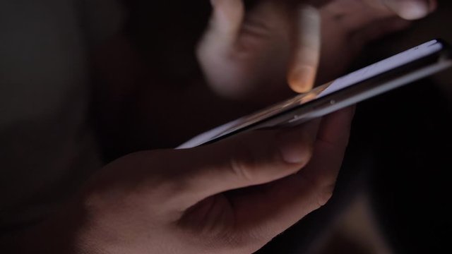 hand of man scrolling the screen, watching video on the phone, close up