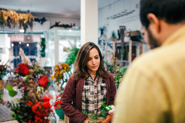 Young woman buying a bouquet of flowers in a florist