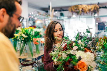 Young woman buying a bouquet of flowers in a florist