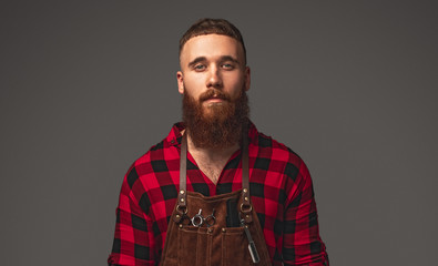 Serious bearded hairdresser looking at camera