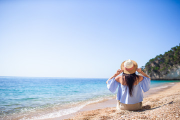 Woman laying on the beach enjoying summer holidays looking at the sea