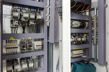 control cabinet in control room. Mechanic's maintenance room concept. Green, yellow, red button on white cabinet. Electrical cabinet in room. Distribution board. panelboard, breaker panel