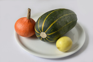 Pumpkin and lemon on a white plate.
