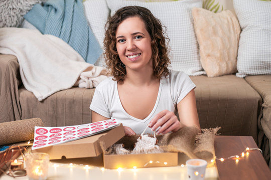 Beautiful woman packaging handmade surprise gift for christmas.