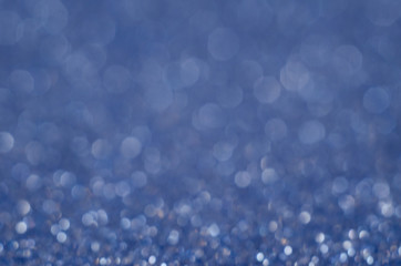 Abstract New Year blue bokeh background with shining defocus sparkles. Blurred glitters shimmering dust macro close up, copy space for text logo