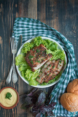 Baked pork belly with spices. Sliced breast served with greens. Traditional dish of Ukraine. Close-up. Space for text.