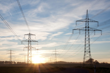 Field with power transport lines in the dusk