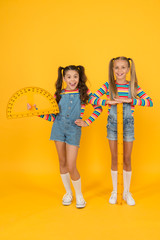 Fototapeta premium School club. School children with measuring instruments. Little girls ready geometry lesson. Cute schoolgirls holding protractor and ruler for school lesson. Studying measurement. Interesting task