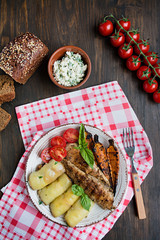 Grilled chicken fillet with baked vegetables. Baked dish. Balanced diet. Wood background. Space for text.