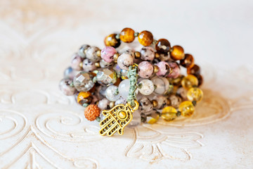 Spiritual mala bead necklace with natural mineral stone beads on wooden decorative background