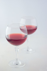  glasses with red wine on a light wooden background