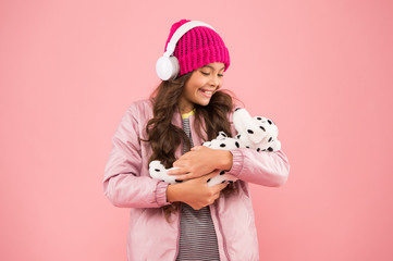 tace care of you. pet care. warm clothes for cold weather. happy little girl play dog toy. pink is her favorite color. small kid listen music headphones. child long curly hair. cosy winter season