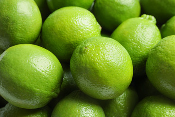 Fresh ripe green limes as background, closeup view