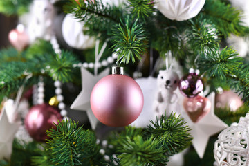 Close up of decorated Christmas tree with pink and white tree ornaments like baubles and pearl garland