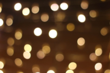 Defocused Christmas background with gold colored bokeh lights.