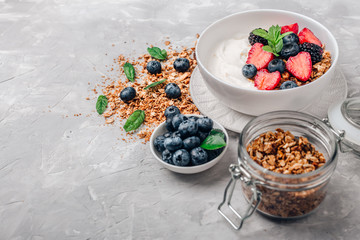 Healthy breakfast with granola, yogurt, fruits, berries on white background.