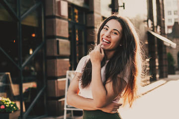 Fototapeta premium Beautiful smiling woman walking in the city on summer day.
